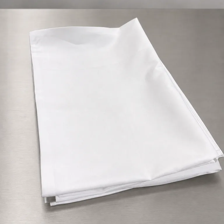 A folded white hotel pillowcase on a stainless bench