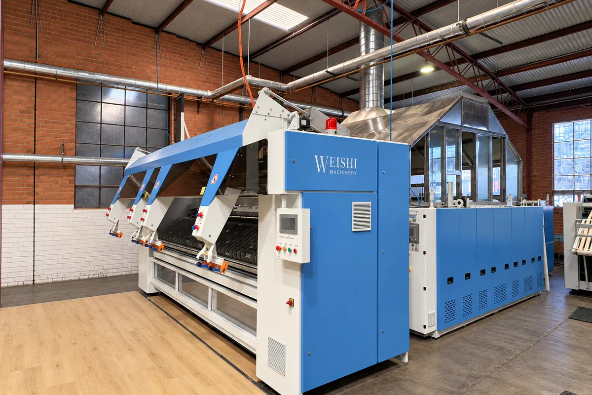 Blue industrial linen finishing equipment inside eWASH