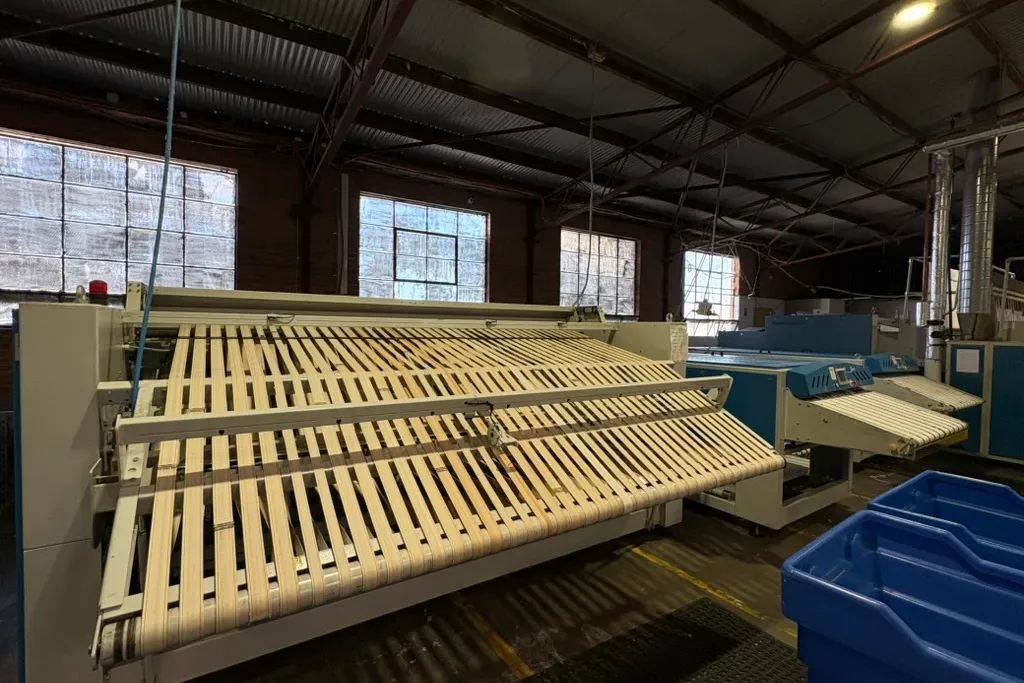 Industrial linen folding and conveyor equipment inside eWASH