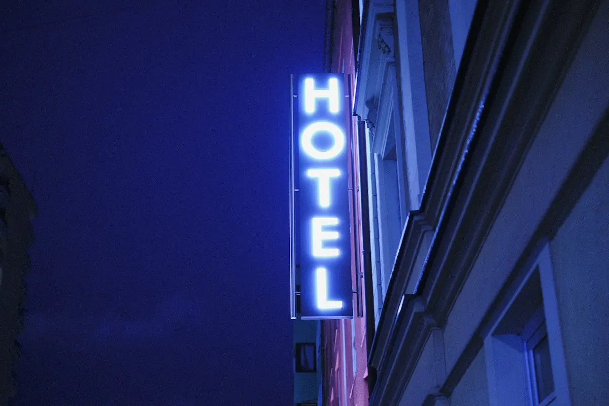 Illuminated blue hotel sign on a building at night